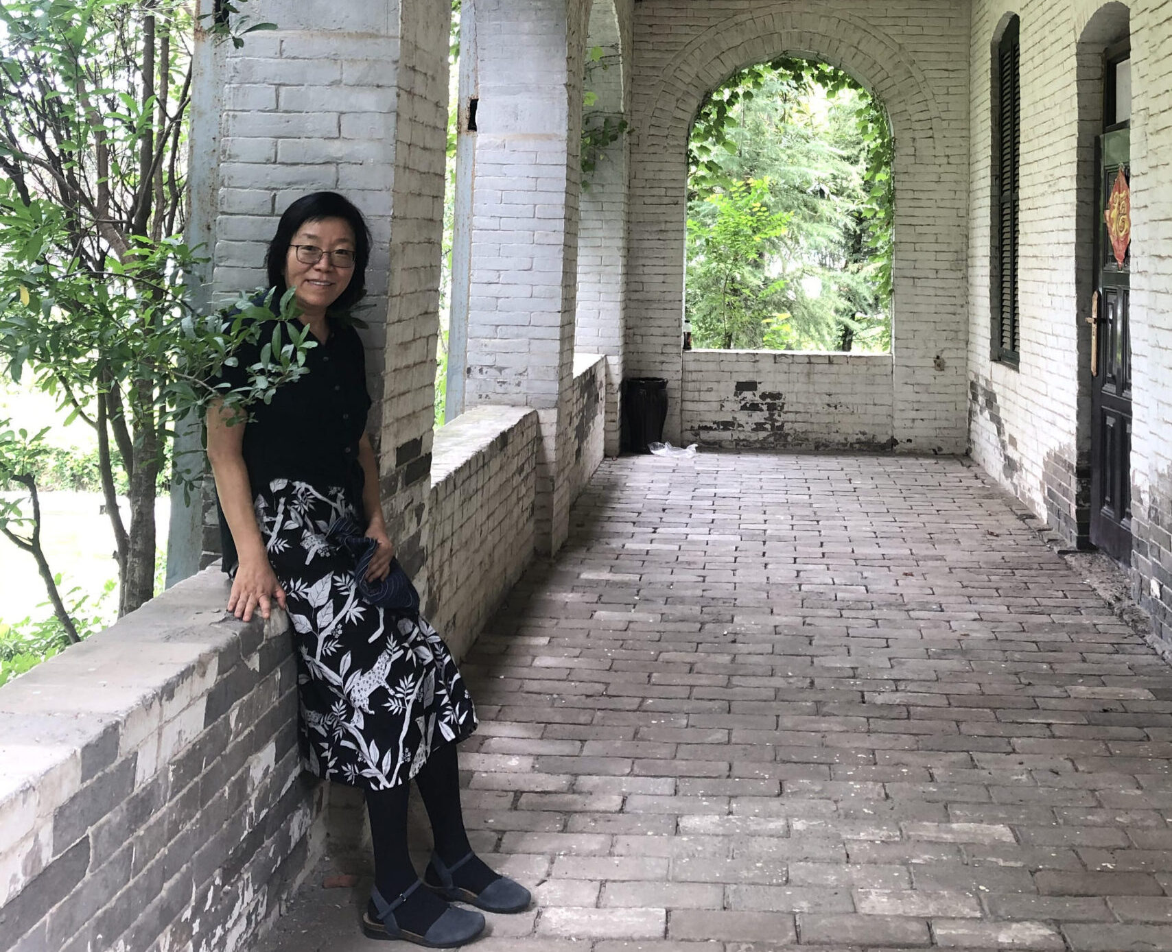 Hong Wang on the porch of the her childhood home, built by Canadian missionaries.